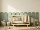 Ein gemütliches, modernes Kinderzimmer mit dem KraftKids Wandpaneel abgerundet Doppelkrepp, einem Holzbett, Plüschtieren, einem Schaukelpferd, geflochtenen Körben, Regalen mit Büchern und Dekoration in sanften Neutraltönen. Natürliches Licht unterstreicht die stilvolle Einrichtung.
