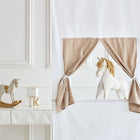 In einem hellen Raum mit dekorativen Wandpaneelen steht das KraftKids Puppentheater Kasperletheater Musselin beige inkl. Teleskopstange. Teleskopstange, ein kleiner weißer Tisch, ein hölzernes Schaukelpferd und verspielte Akzente - ideal für fantasievolle Kinderspiele.