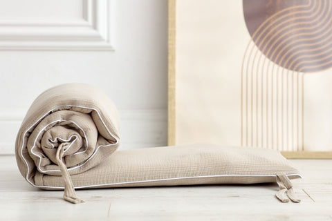 Bettumrandung aus Musselin in Beige im Babyzimmer.