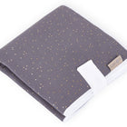 Die KraftKids Reisewickelunterlage Musselin goldene Punkte auf Grau ist eine platzsparende Wickelauflage mit weißen Kanten und beigem Stoffetikett - ideal für unterwegs und perfekt für die Reise mit Ihrem Baby.