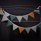 Zwei Stränge der KraftKids Wimpelkette "Pusteblumen auf Gelb und Grau" mit Dreiecksfähnchen hängen auf einem dunklen, rustikalen Holzrahmen vor schwarzem Hintergrund.