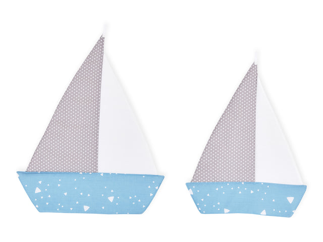 Triangoli arrotondati per barche a vela bianchi su blu