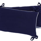 Die KraftKids Bettumrandung Nestchen Musselin in dunkelblau, aus 100% Baumwolle, mit weißen Paspeln und Schleifen an den Ecken, wird überlappend auf weißem Hintergrund präsentiert.