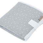 Die KraftKids Reisewickelunterlage Musselin grau Pusteblumen ist eine gefaltete hellgraue Musselin-Wickelunterlage mit weißem Pusteblumen-Muster, weißer Borte und braunem Stoffanhänger - perfekt als platzsparende Wickelunterlage für unterwegs.