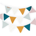 Die KraftKids Wimpelkette goldene Punkte auf Musselin zeigt pastellrosa, senfgelb, teal und hellblau und cremefarbene Fähnchen mit goldenen Punkten auf einem weißen Band - perfektes Kinderzimmer-Deko in zwei überlappenden Reihen.