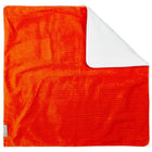 Eine leuchtend orangefarbene KraftKids Wickelunterlage Cord Breitcord Orange Reinorange mit gerippter Textur und einer Ecke, die gefaltet ist, um die glatte, weiße, wasserfeste Unterseite zu zeigen, dargestellt auf weißem Hintergrund.