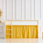 Ein minimalistisches Kinderhochbett mit Naturholzrahmen und KraftKids Hochbettvorhänge Set 2+1 Doppelkrepp Gelb Senf für Kura Bett, neben einer geflochtenen Vase mit Pampasgras und zwei Holzhockern, vor einer weiß getäfelten Wand.